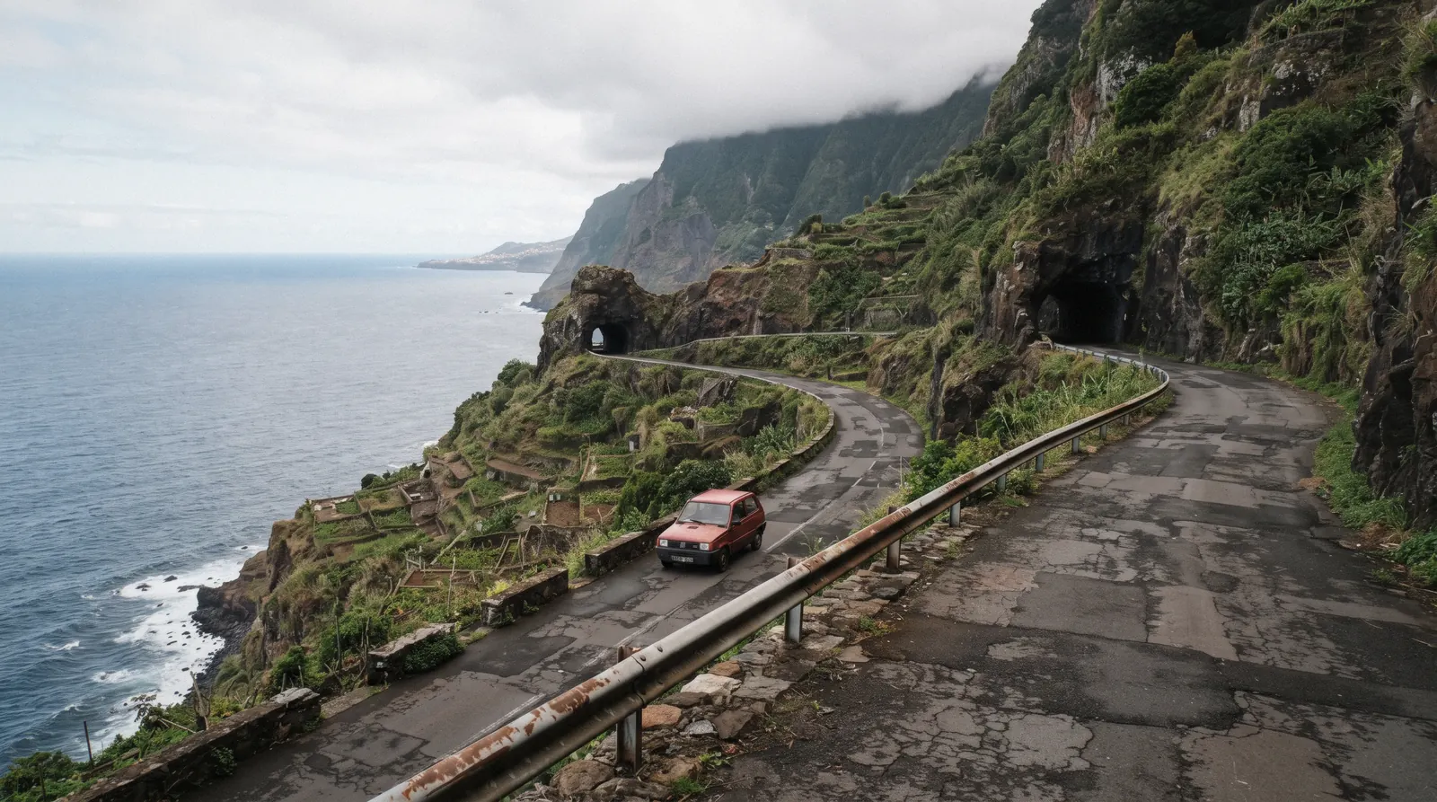 Aerial view of the north coast road curving above the ocean with the central mountains behind, an image to accompany the Madeira map on this page