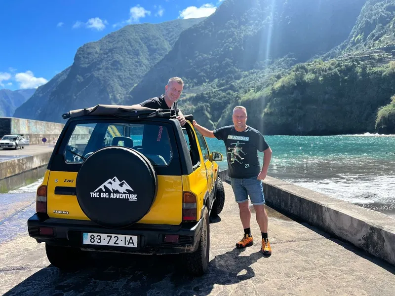 An open-top jeep parked above the Porto Moniz volcanic pools on a Madeira full-day jeep tour in Porto Moniz, Madeira
