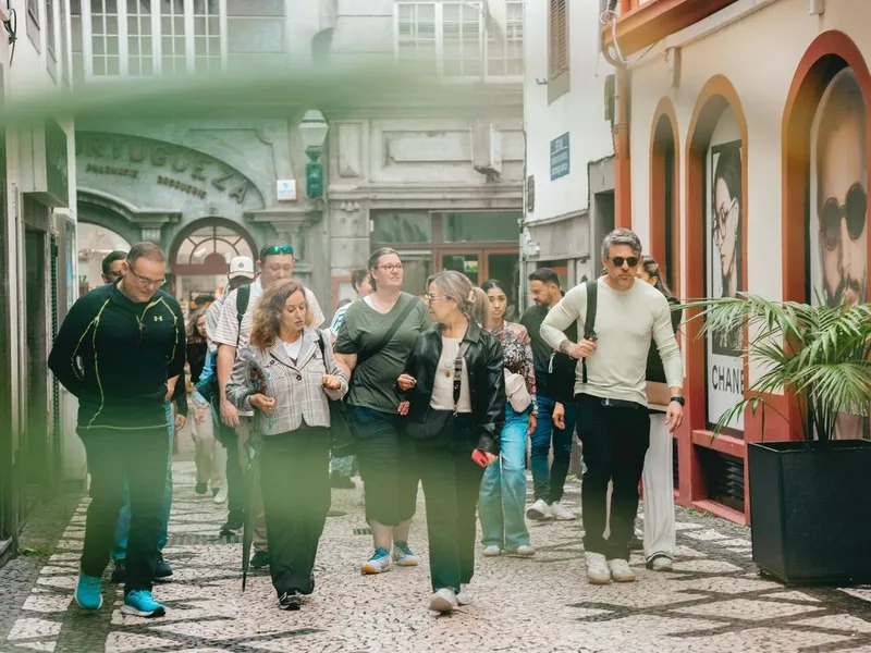 A guide leading a small group past market stalls in Funchal on a Taste Funchal food, wine and cultural tour in Funchal, Madeira