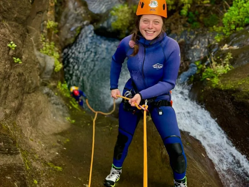 A canyoner rappelling down a waterfall in a Madeira ravine on an Intermediate Canyoning Adventure Level 2 in Curral das Freiras, Madeira