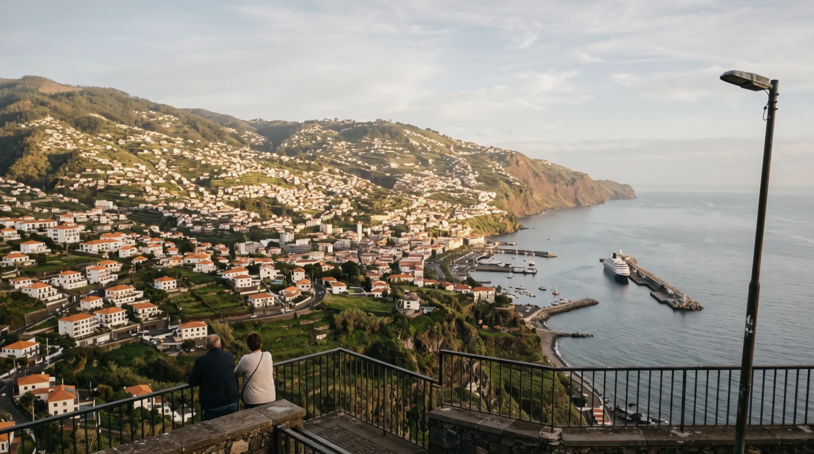 Terraced white houses of Funchal stepping down to the harbour in late light, the first answer to where to stay in Madeira